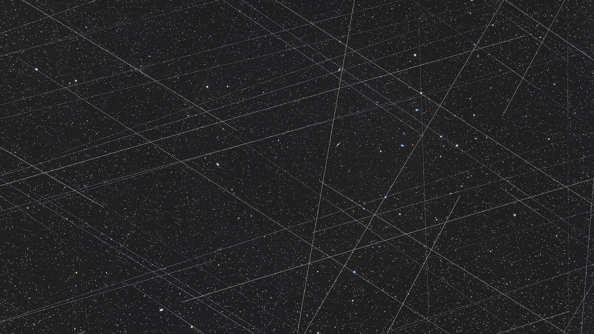 An image of many criss-crossing beams of light in the starry night sky