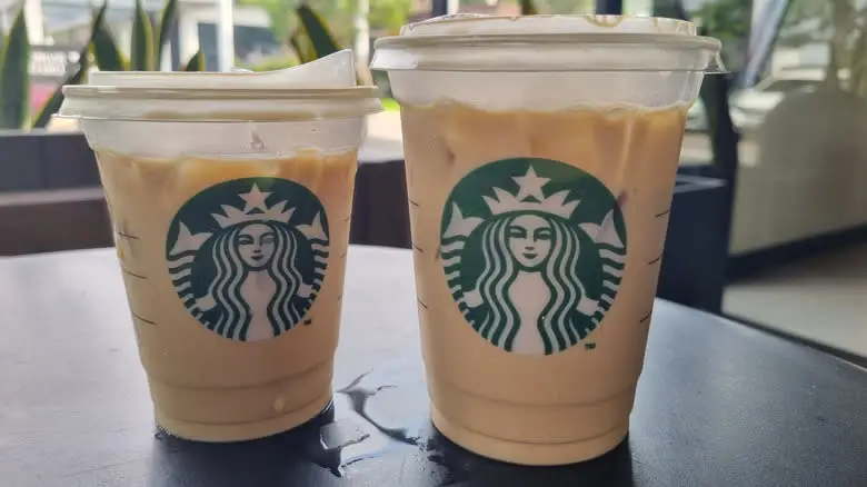 Two Starbucks iced lattes on a black table