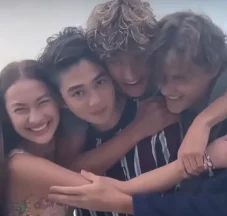 Four people smiling and hugging each other joyfully, with relaxed, casual attire, enjoying a moment together