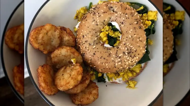 Overview of an everything bagel sandwich with Dunkin' hash browns