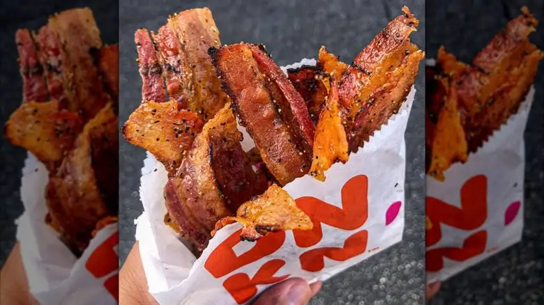 Hand holding a bag of Dunkin' Snackin' Bacon