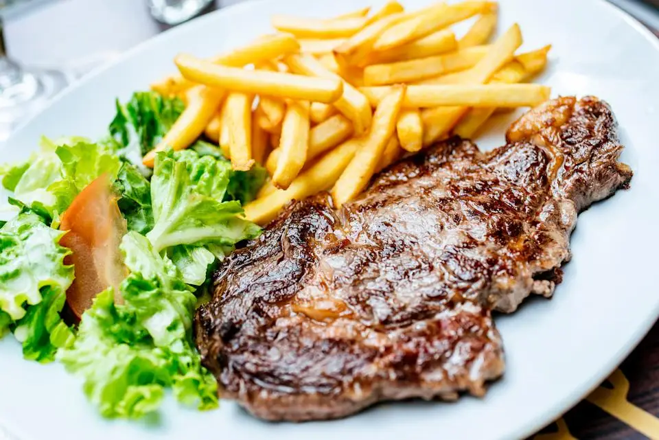 Plate of beef fillet with salad and chips