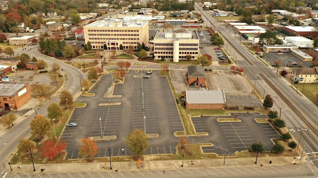 Aerial view of a parking lot with some buildings around it