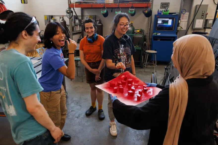 Rising junior Huda Abdesumad, 18, shows off spray painted paper squares she completed for a model prototype to the other Washington University architecture students June 3, 2025 at Washington University in St. Louis, Missouri.
