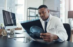 A person at a desk looking at medical imaging.