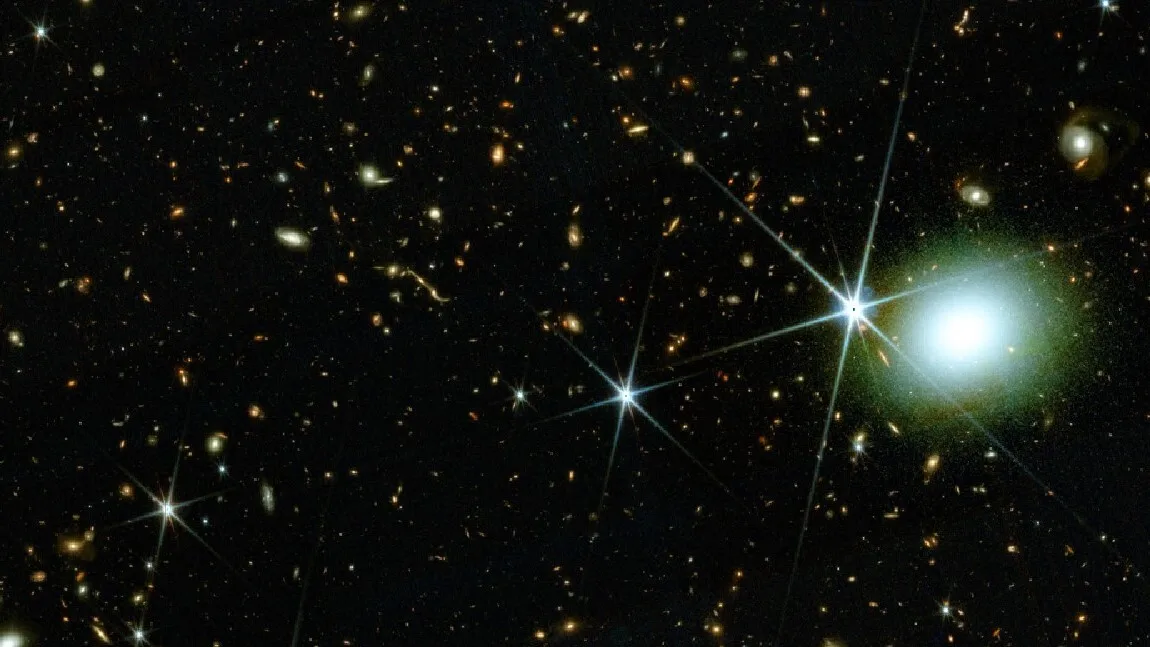 Galaxies on a dark section of sky and a bright white blob toward the right.