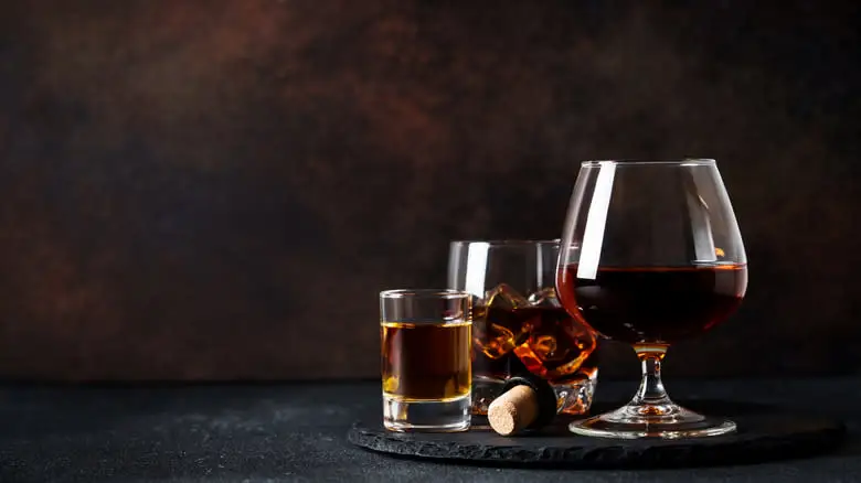Various shades of whiskey served in different glassware