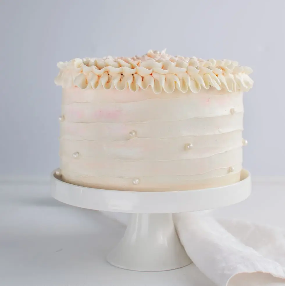 beautiful birthday cake decorate with edible pearls on white neutral background copy space