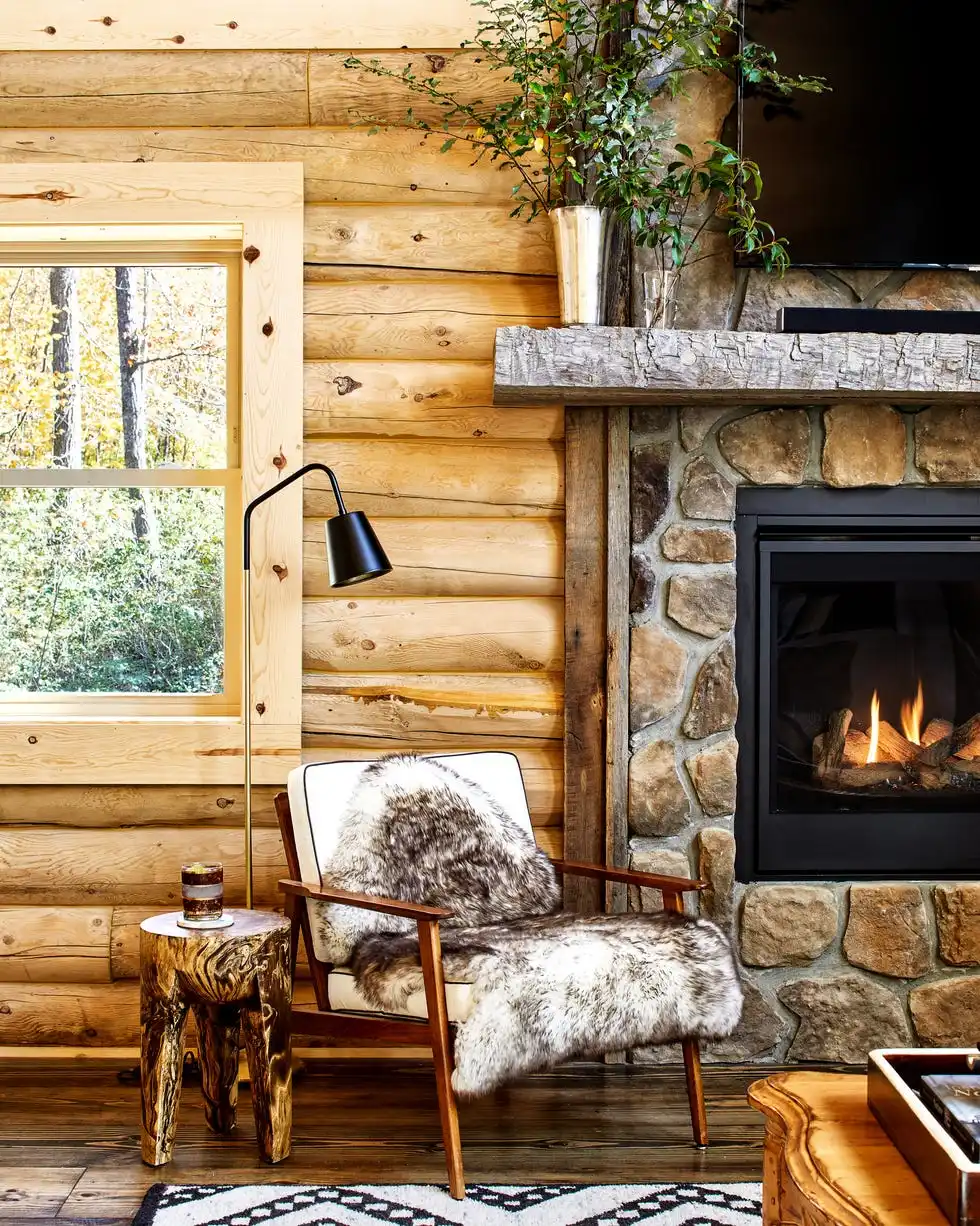 blonde log cabin living room with sitting chair and tv over mantel