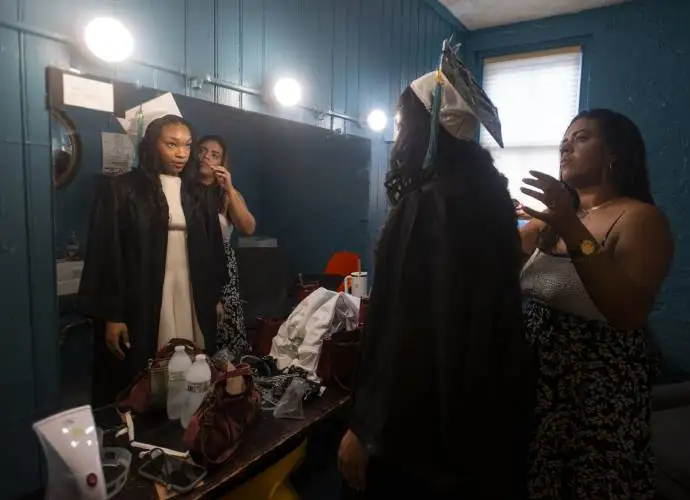 Pioneer Valley Performing Arts Charter School  Senior Coordinator Daphne Correa, right, fixes the hair of graduate Legacy Moye before the graduation ceremony at the Academy of Music, Thursday, in Northampton.