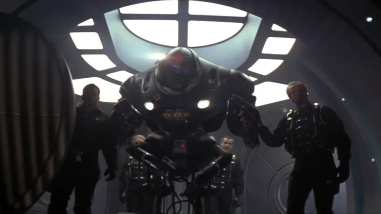 Matt LeBlanc's Major Don West stands beside a robot and William Hurt's Professor John Robinson in Lost in Space