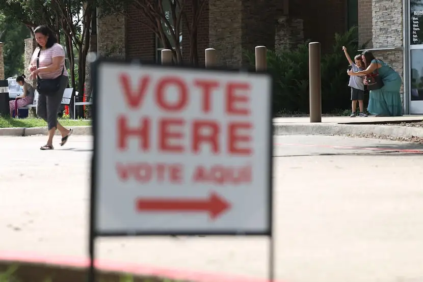 People walk out of the poling center at the John and Judy Gay Public Library in McKinney,...