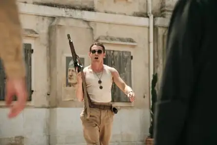 A white soldier in sunglasses holds a gun and shouts