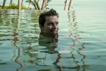 A white man with tousled hair swims 
