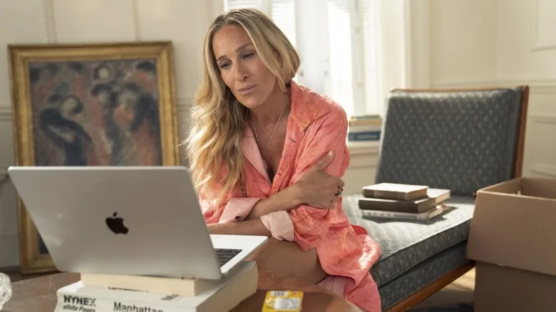 Carrie looking at her laptop in her living room in And Just Like That