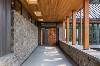 Refined stonework and a covered walkway leading to doors designed by Leroy Setziol in the Brown-designed West Hills house. Photo: David Papazian