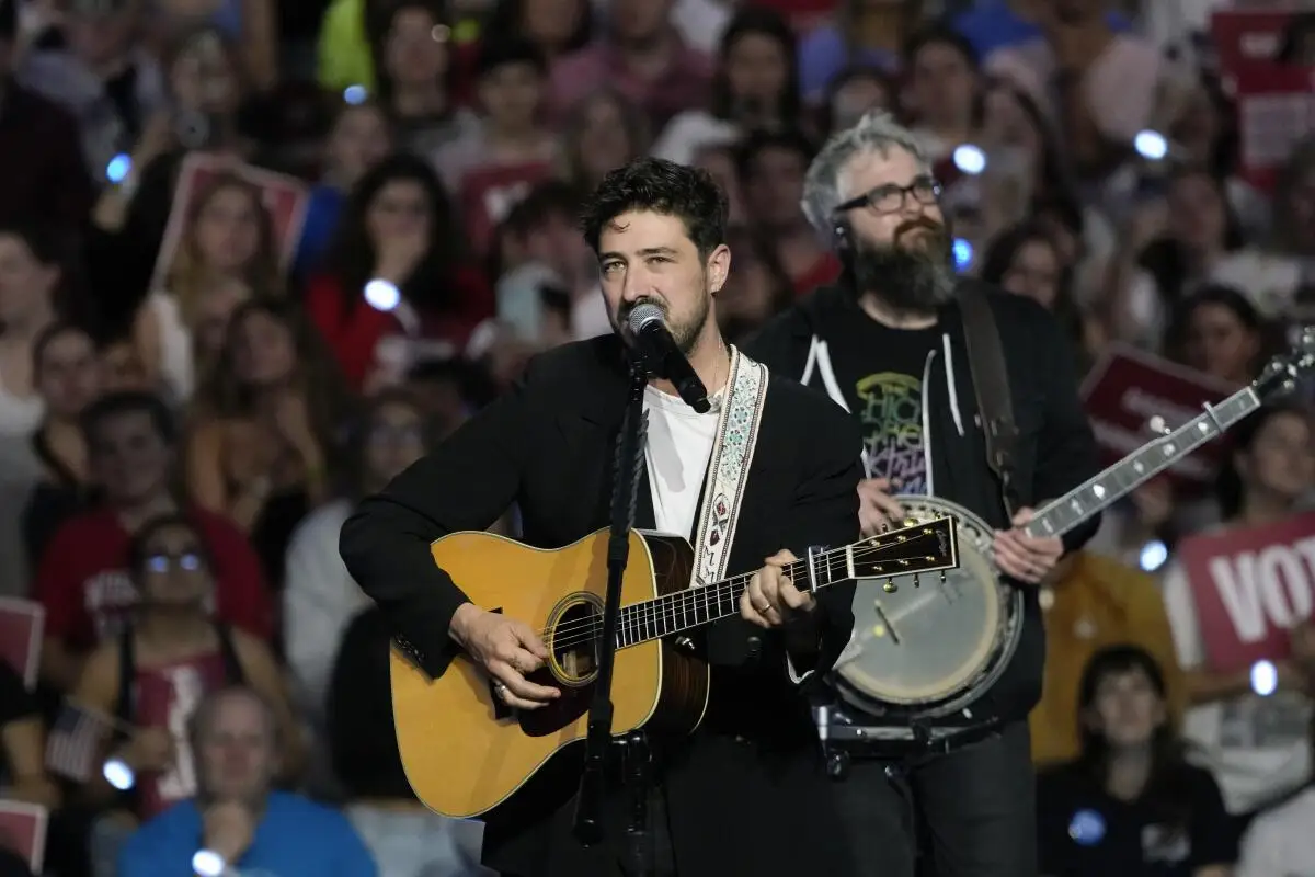 A guitarist and a banjo player perform before a large crowd.