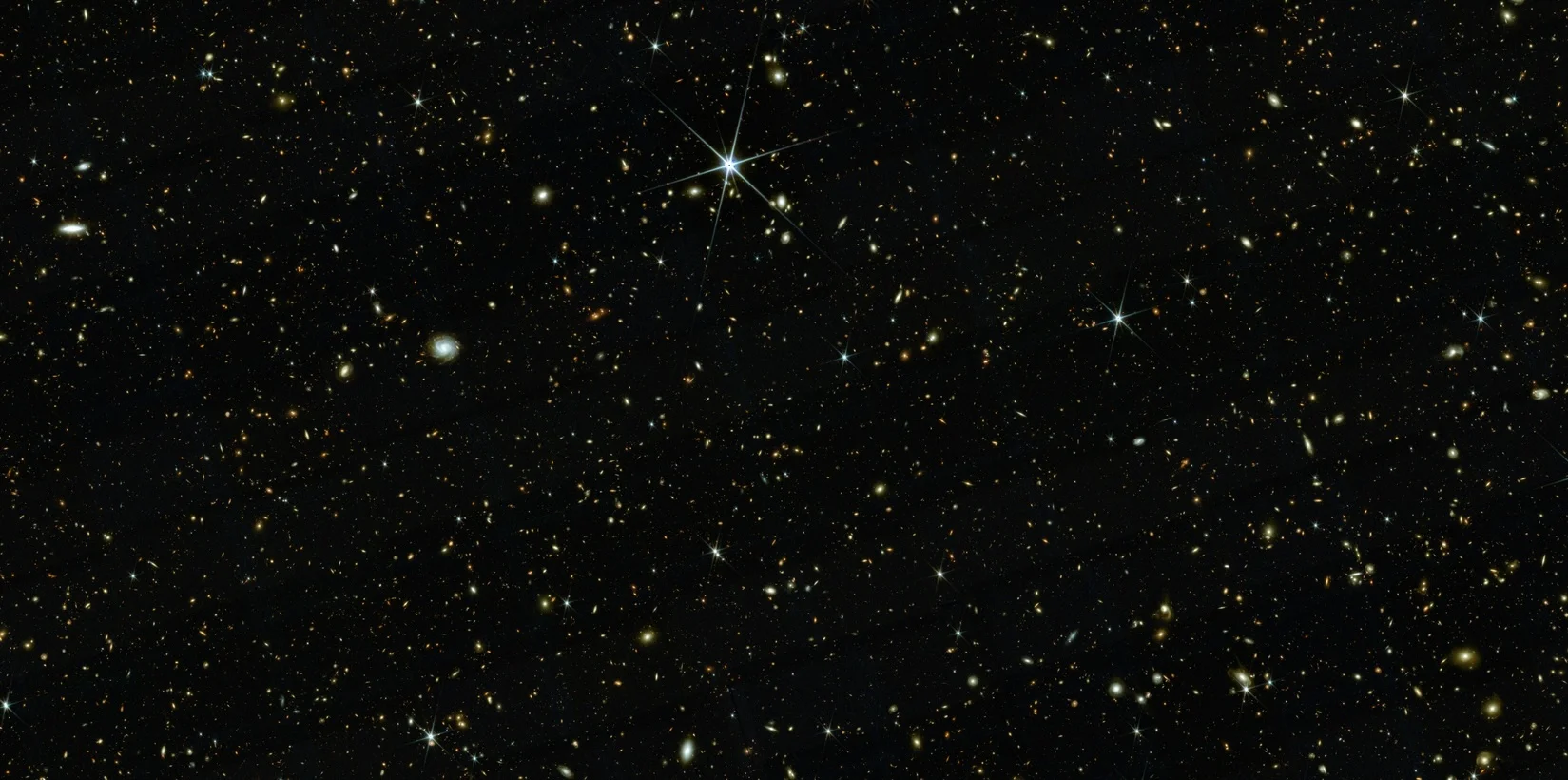 an image of outer space showing many small, sparkling galaxies