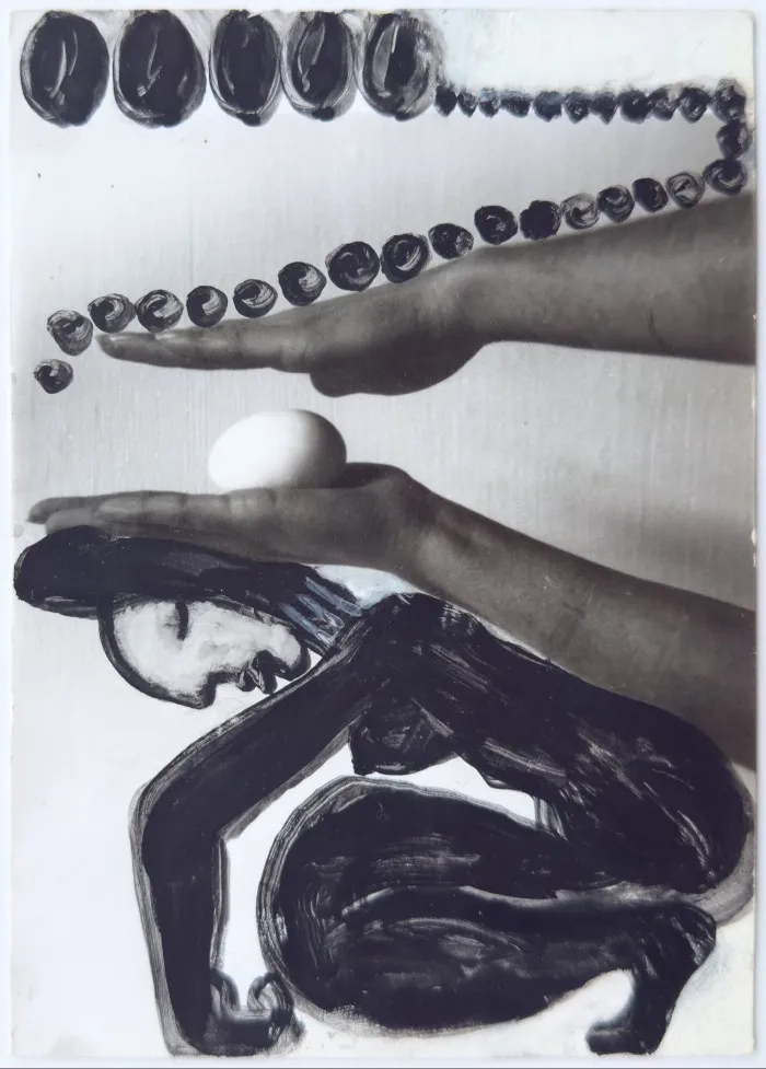 Gelatin silver print of a hand holding an egg over a painting of a crouched body