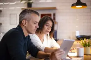 Couple in their 40s or 50s looking with concern at online mortgage rates