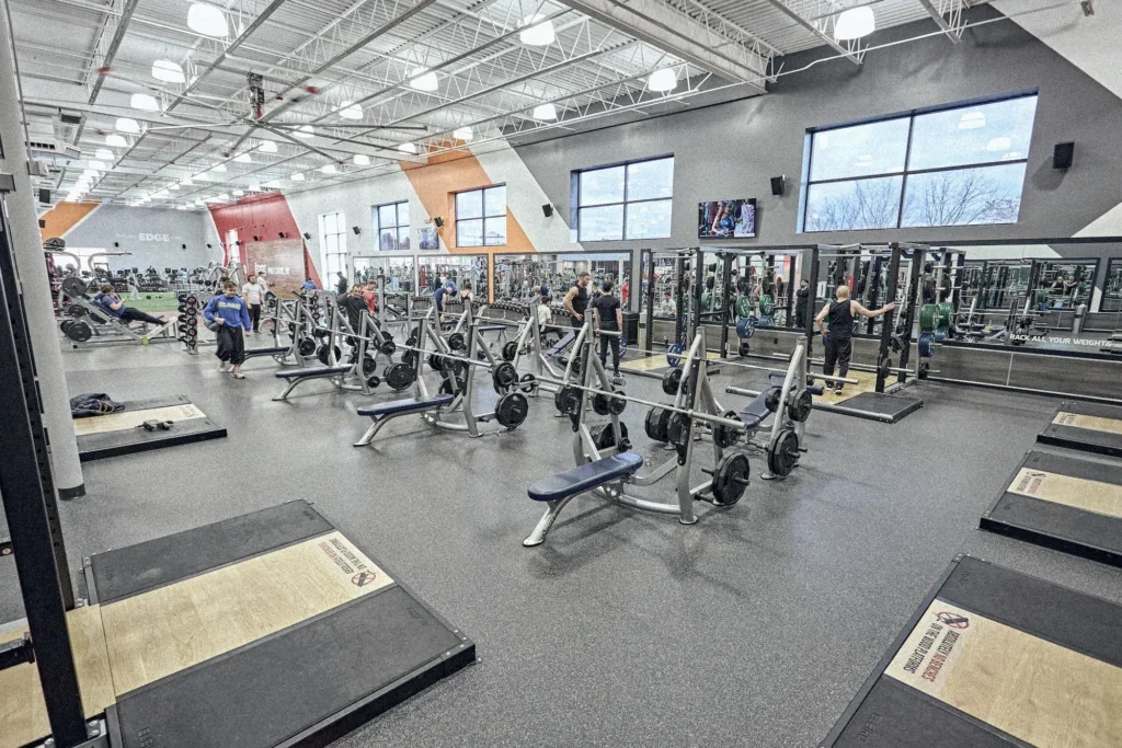 fitness floor featuring bench presses and power racks inside a gym