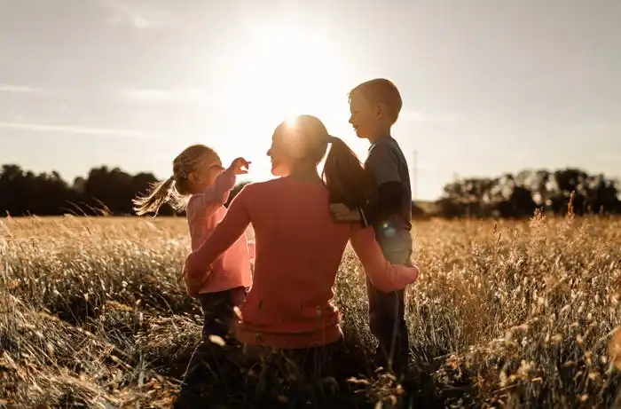Stock image of mom in a field with two kids