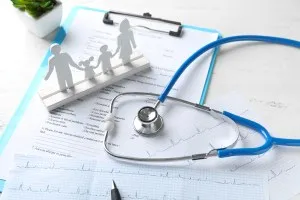 Composition with family figure and stethoscope on wooden table. Health care concept