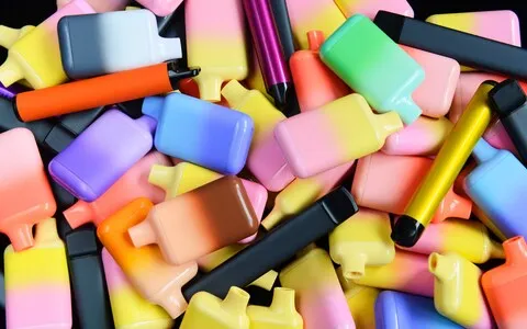 A pile of multi-coloured disposable vapes