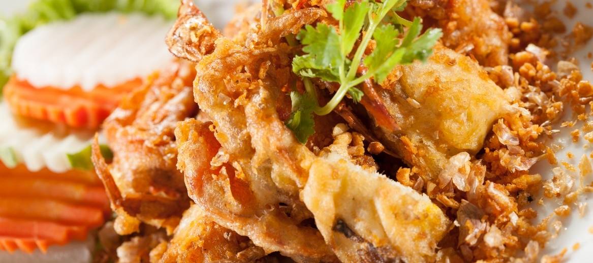 Panko-coated soft shell crabs are deep fried and served with a ginger ponzu sauce for dipping.