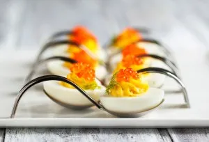Deviled eggs with red caviar in a spoon
