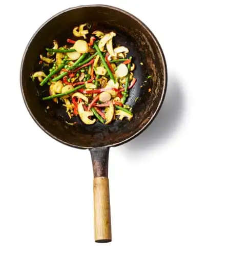 Start cooking. Put the oil in a wok set over a high heat until smoking, then add the garlic and ginger mixture. Stir-fry for about 30 seconds, until fragrant, then tip in all the vegetables. Stir-fry for a couple of minutes, then push to one side of the wok.