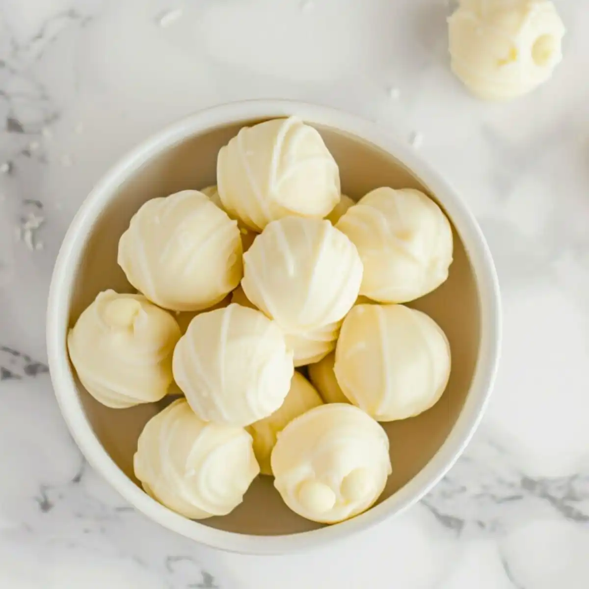 Top view of white chocolate truffles in a bowl.