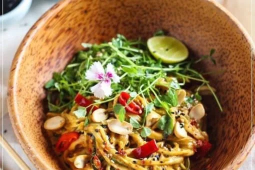For a vibrant and refreshing experience, savor the Vegan Pad Thai featuring zesty peanut butter dressing, zucchini zoodles, and an array of colorful garnishes.