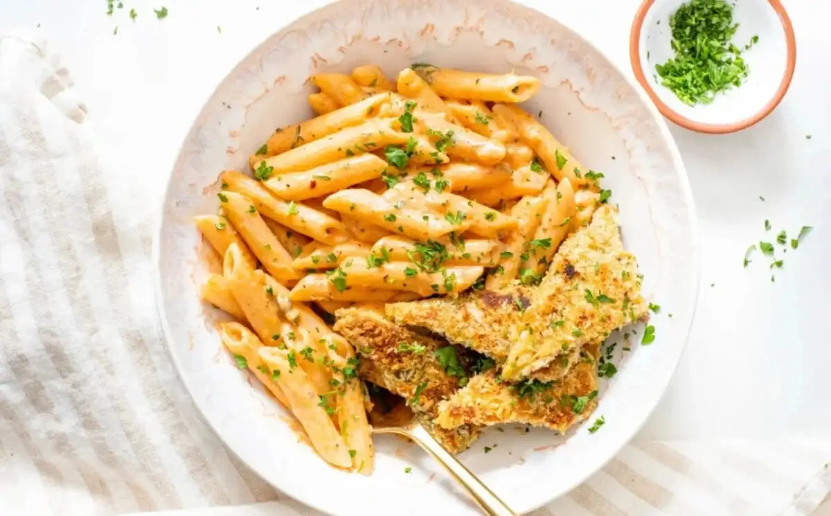 Photo shows a dish of Cajun-style pasta in a creamy sauce with panko crusted tempeh