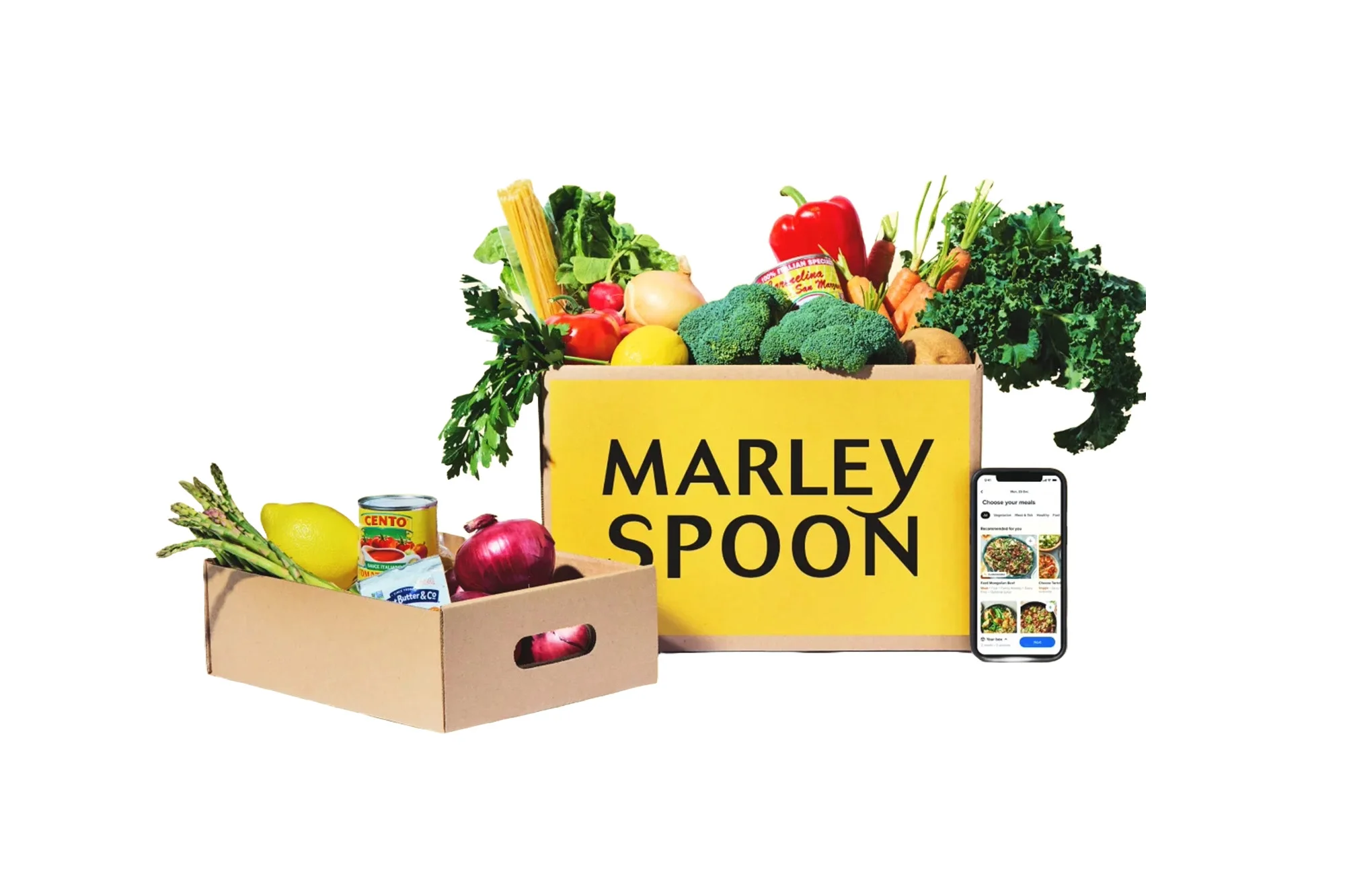 A Marley Spoon box filled with produce, with a phone open to the brand's site next to it