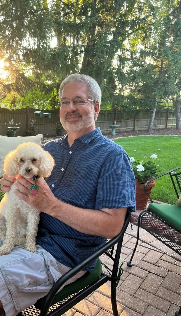 Ed Weinberger of Tinley Park, Illinois, at home on the patio with his 15-year-old poodle Aimee in July 2023, likes to entertain guests with a variety of recipes, both new and heirloom favorites, for his planned menus. (Philip Potempa/for Post-Tribune)