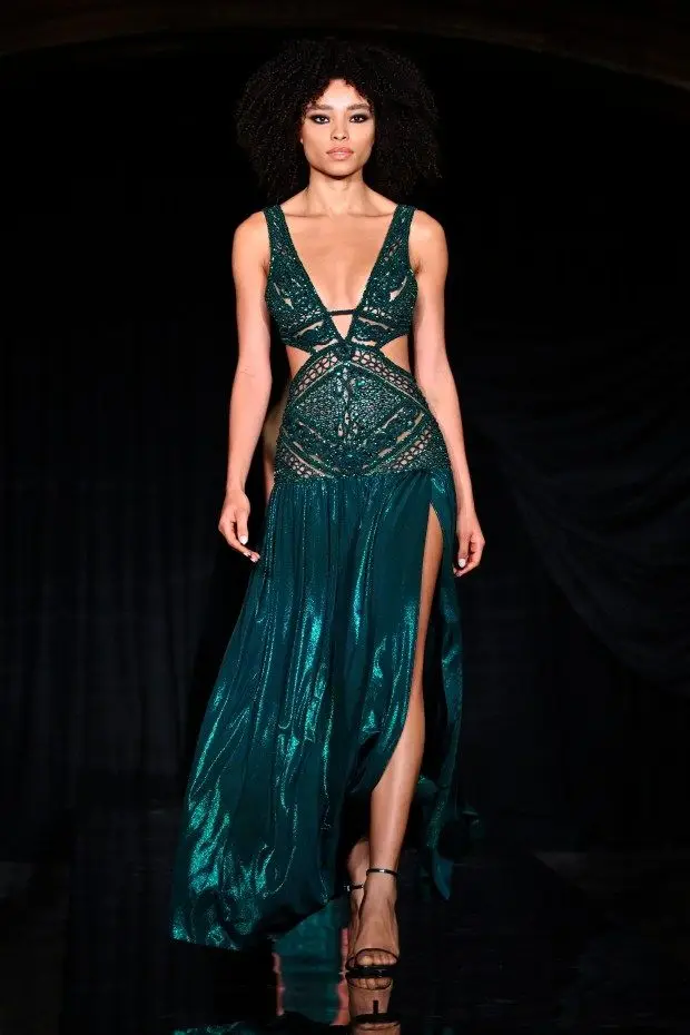 NEW YORK, NEW YORK - FEBRUARY 10: A model wears a deep green v-neck dress with waist cutouts and cutout detail throughout the bodice with a high-slit full skirt at the PatBo runway show at Surrogate's Court during New York Fashion Week on February 10, 2024 in New York City. (Photo by Shannon Finney/Getty Images for NYFW: The Shows)
