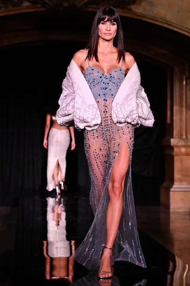 NEW YORK, NEW YORK - FEBRUARY 10: A model wears a slate grey beaded maxi-dress with a bustier top and a sheer skirt with a high leg slit, topped with a cocoon jacket in a shimmering crosshatch pattern at the PatBo runway show at Surrogate's Court during New York Fashion Week on February 10, 2024 in New York City. (Photo by Shannon Finney/Getty Images for NYFW: The Shows)