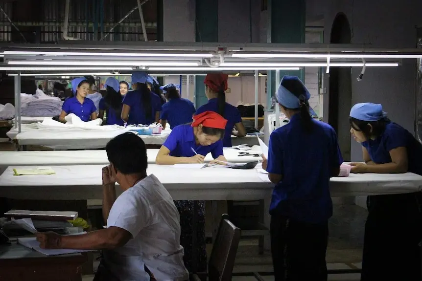 Women measure fabric against patterns.