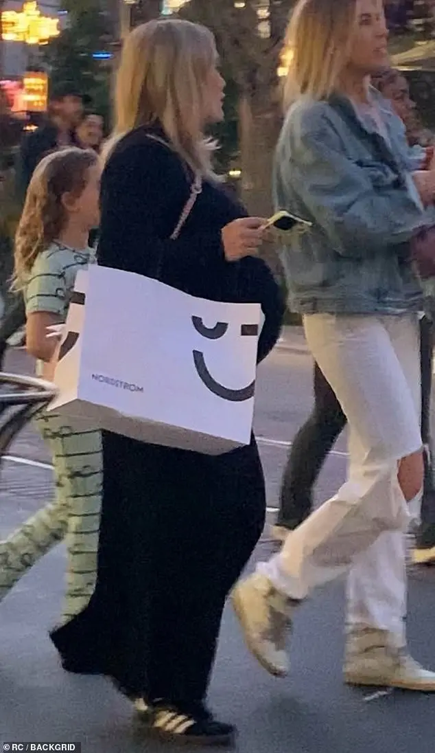 Thee was no hiding her growing baby bump when the actress and singer stepped out in a black dress and matching sneakers, alongside her friend and daughter Banks to her left