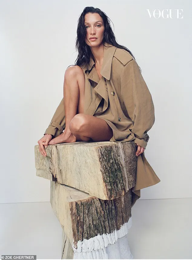 Bella also donned a beige trench coat while posing on blocks of timber