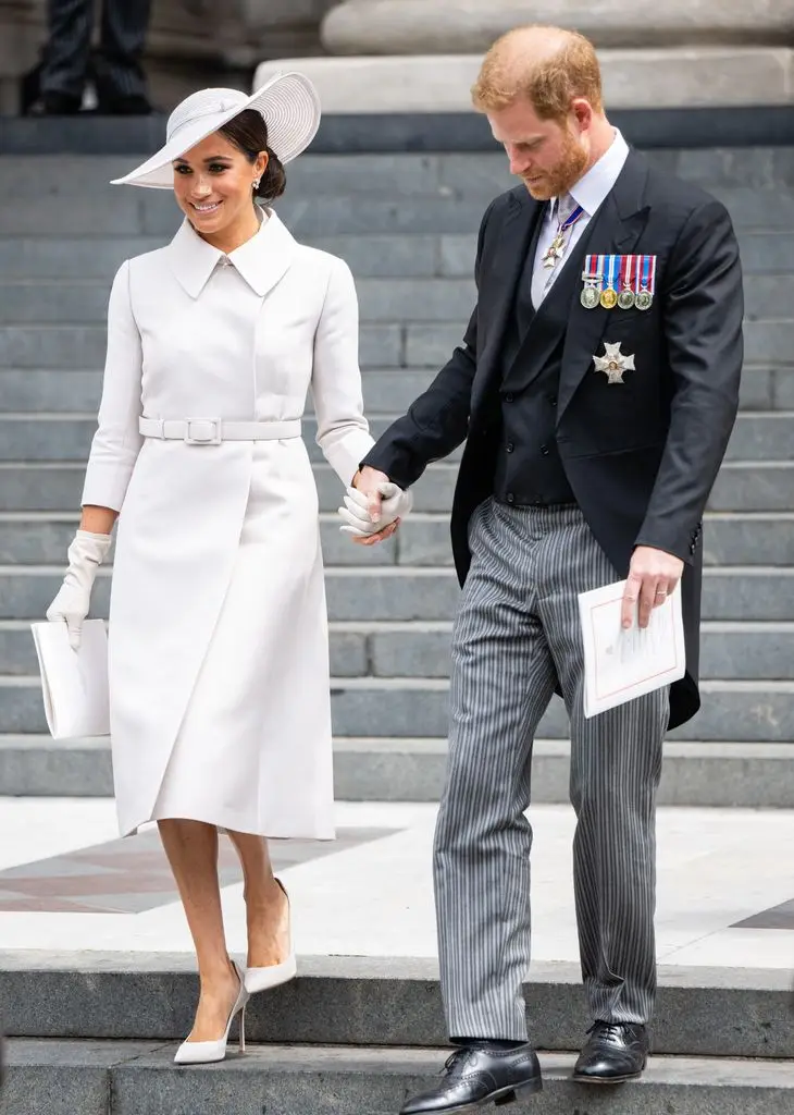 Meghan in white holding harry's hand