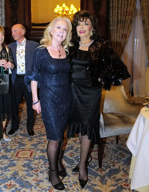 Inside, Joan placed a hand on her hip as she beamed next to a guest wearing a knee-length navy gown