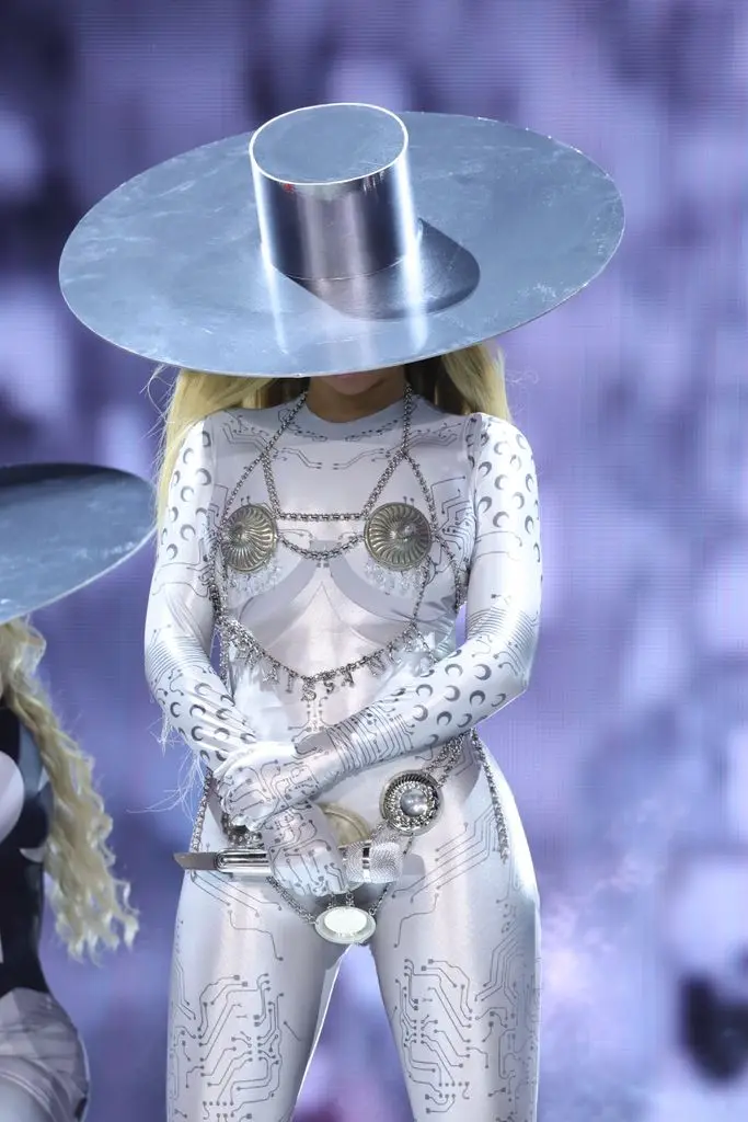 Beyonce in silver catsuit and hat looking down