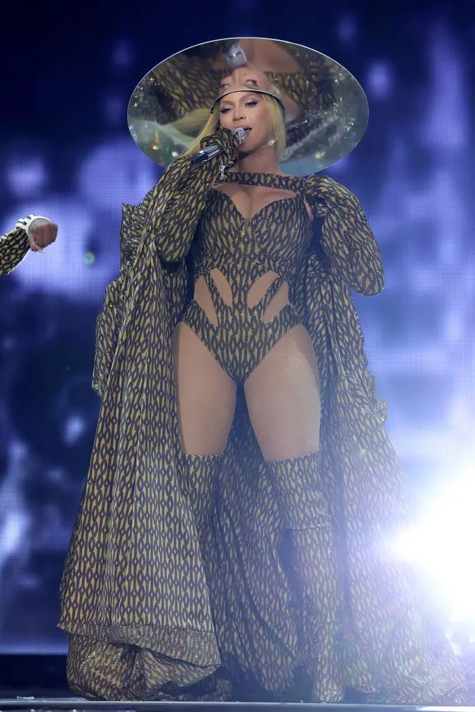 Beyonce on stage in printed bodysuit, boots and hat