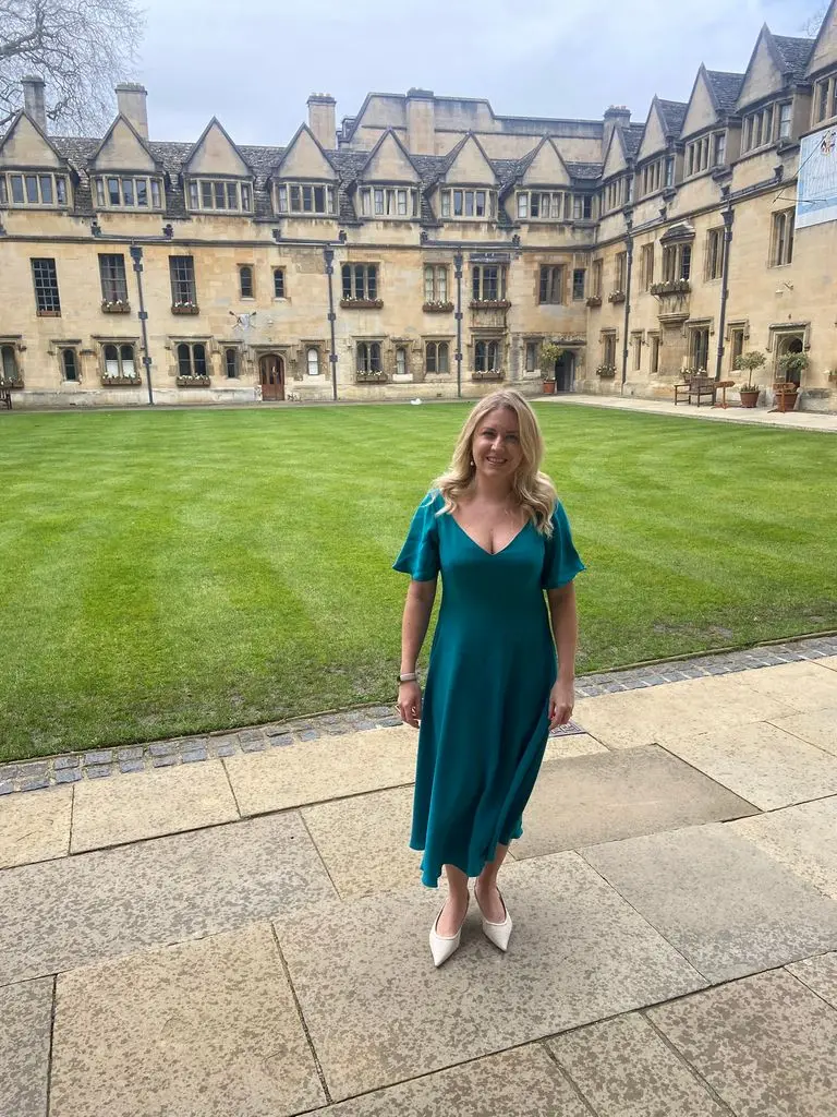 Kate standing at Oxford college in Modify dress from Modiste in teal