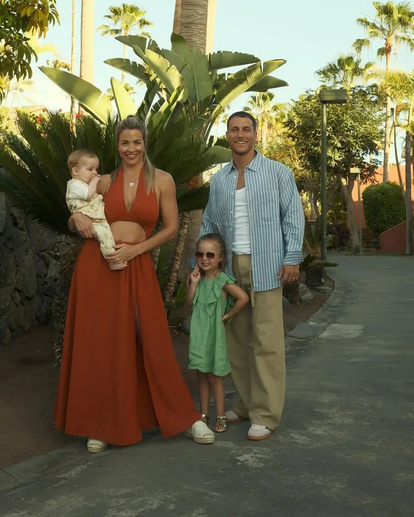 family of four posing outside in summer outfits