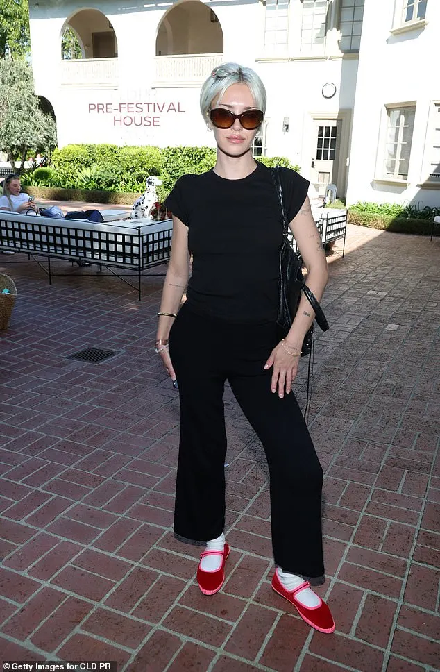 Lisa Rinna's daughter Delilah Belle, 25, sported a casual all-black look, wearing a t-shirt, bell bottom pants and red shoes with white socks