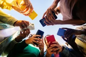 Young group of teenage student people using smart mobile phone outdoors