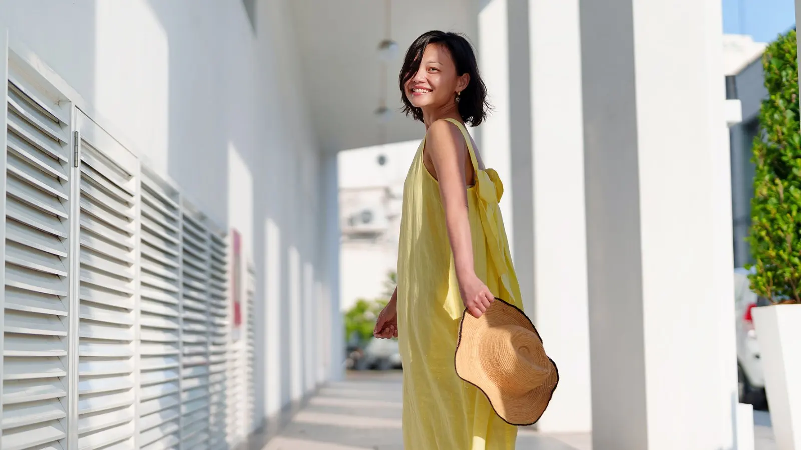 A cheerful solo woman traveler, looks back with a beautiful smile while joyfully exploring Georgetown, Penang.